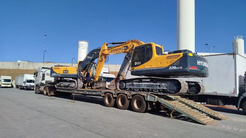 Máquina pesada em prancha de transporte
